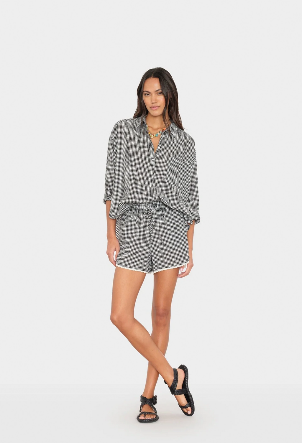 Woman wearing a checkered shirt and shorts set on a white background