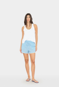 Woman wearing a white tank top and light blue shorts on a white background