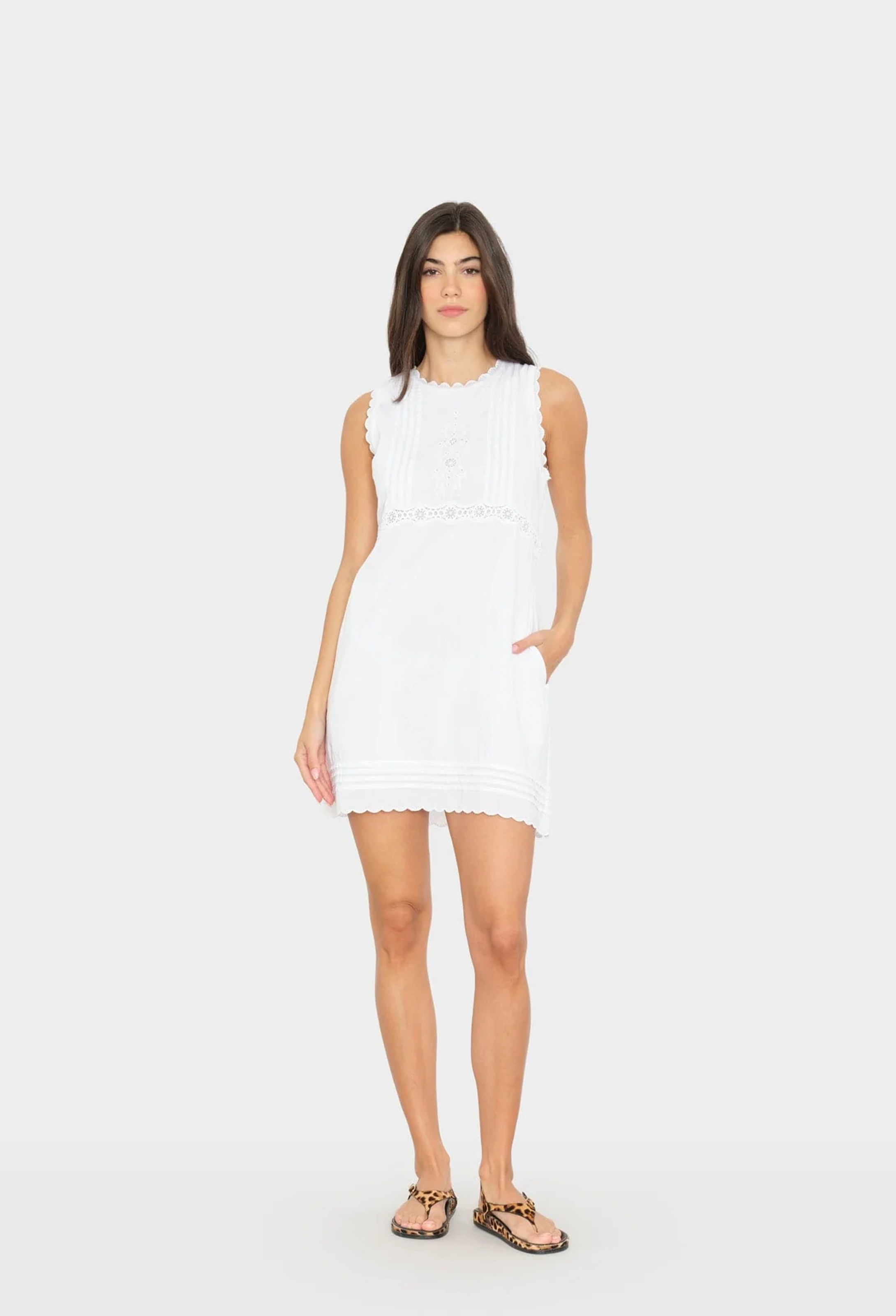 Woman wearing a white sleeveless dress on a white background