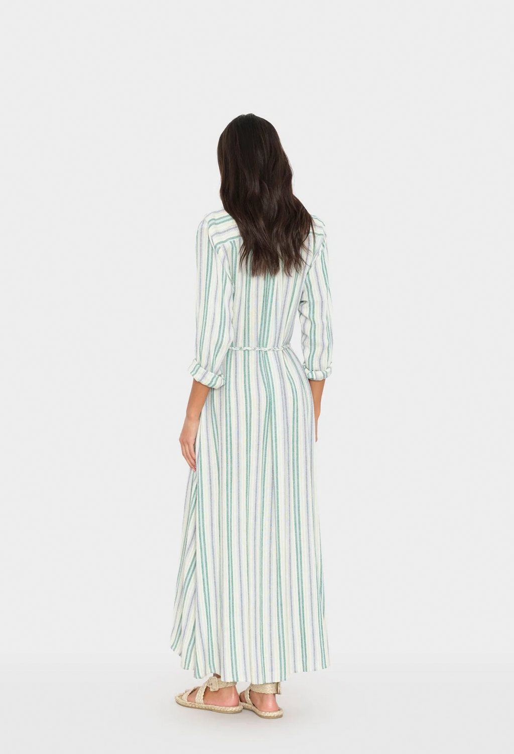 Woman wearing a long striped dress on a white background