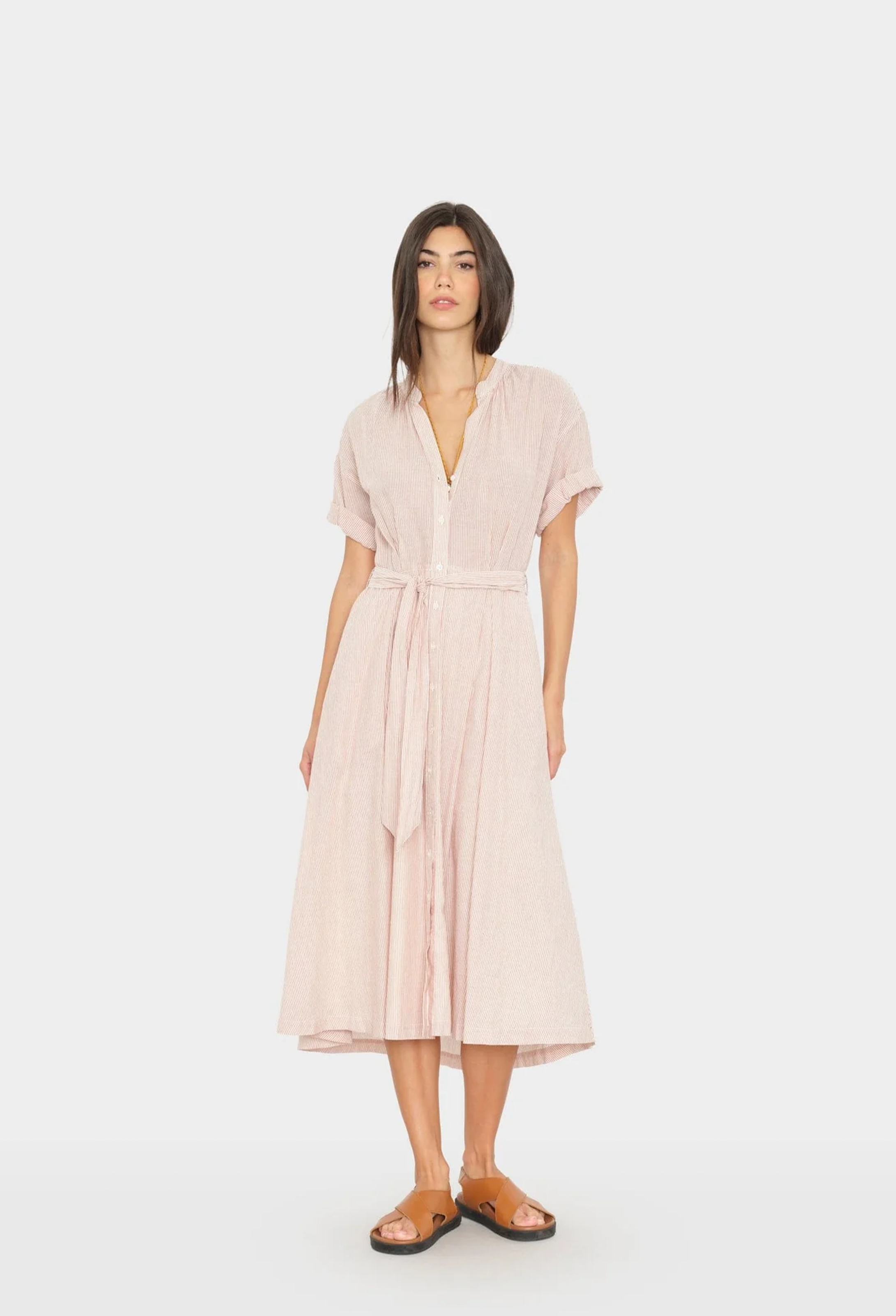 Woman wearing a light pink dress on a white background