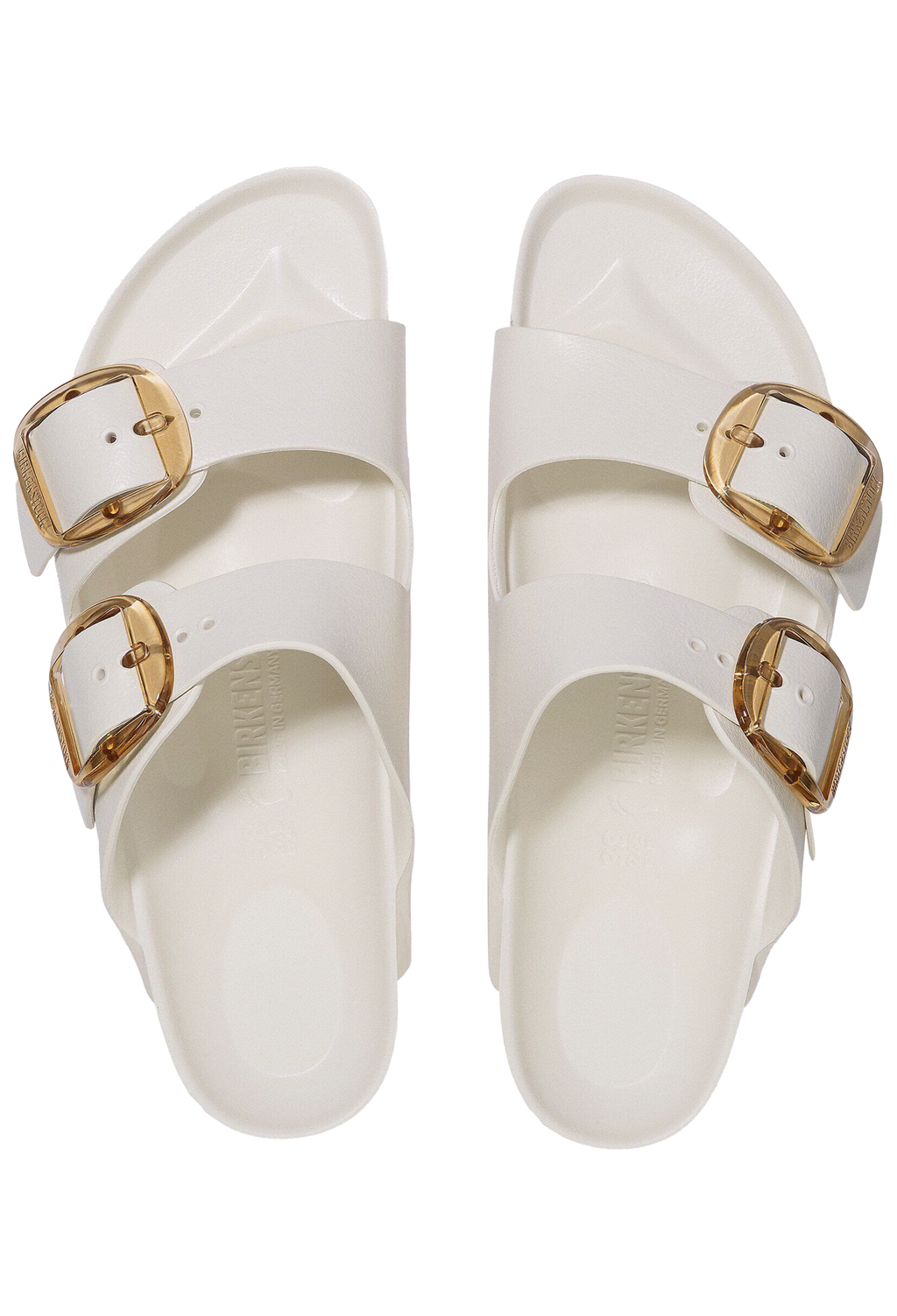 White sandals with gold buckles on a white background