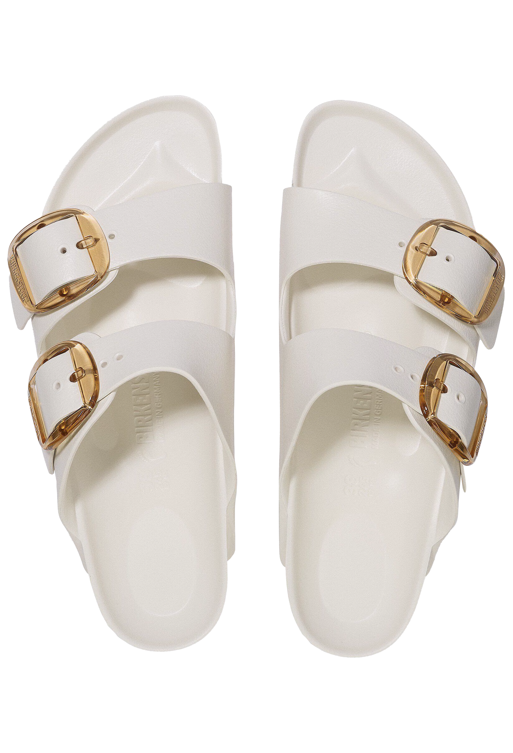 White sandals with gold buckles on a white background