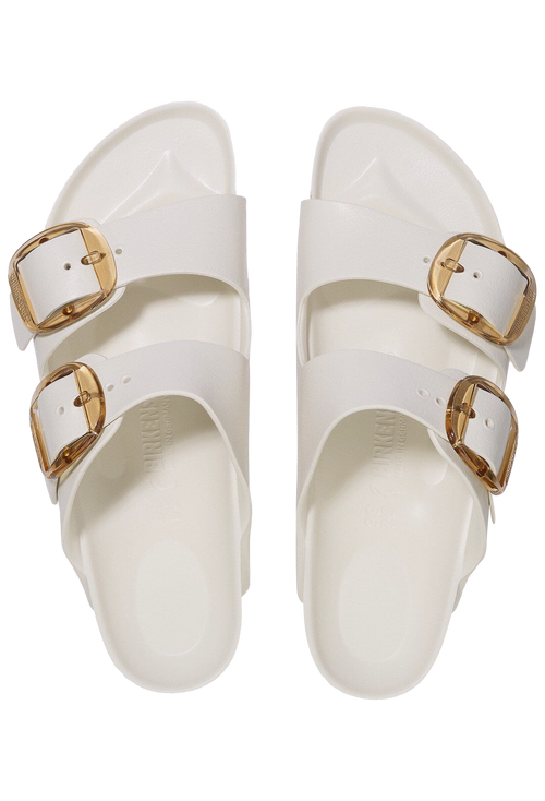 White sandals with gold buckles on a white background