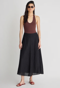 Woman wearing a brown halter top and black long skirt on a white background