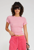 Woman wearing a pink striped shirt and pink pants with sunglasses on a white background