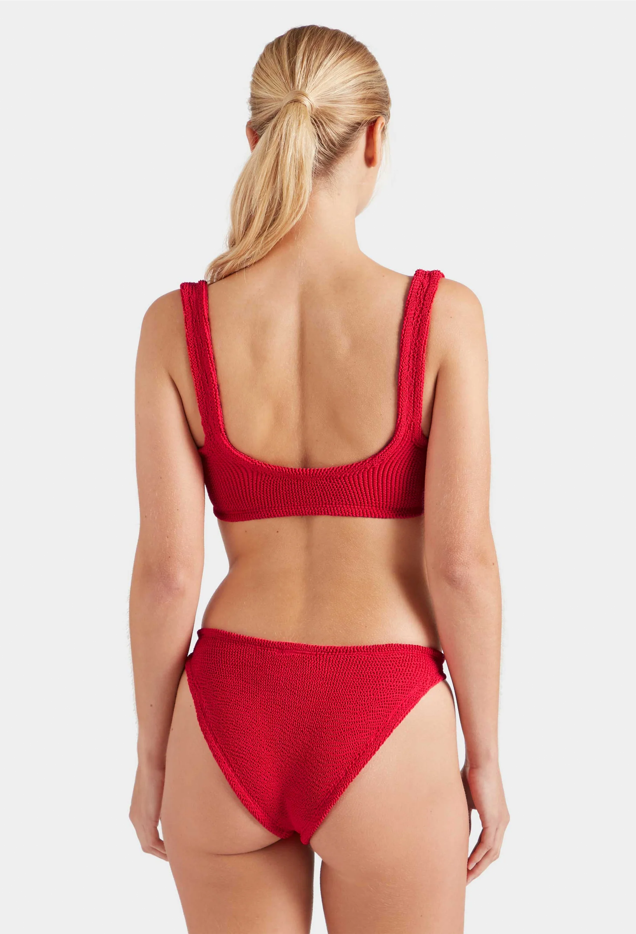Red bikini worn by a model on a white background