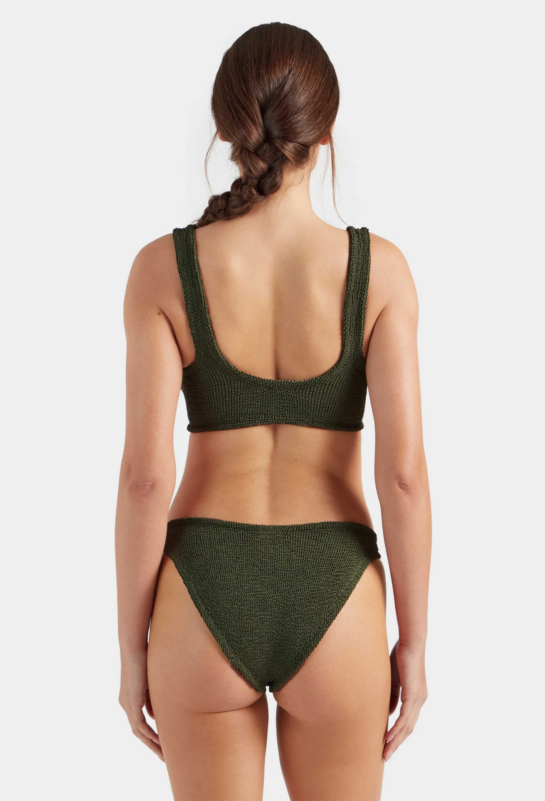 Woman wearing a green bikini set on a white background