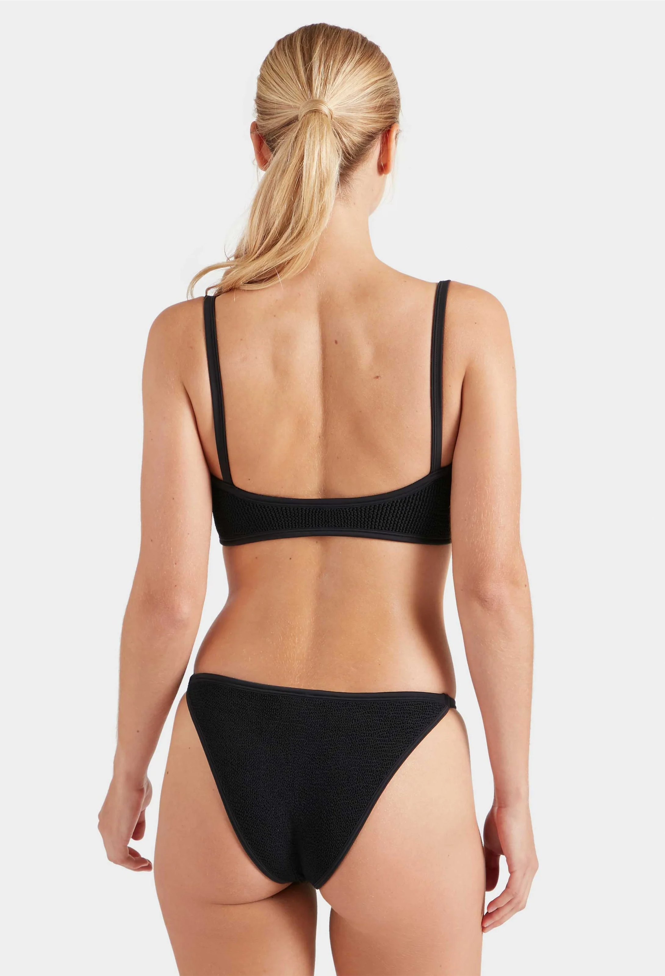 Person wearing a black bikini on a white background