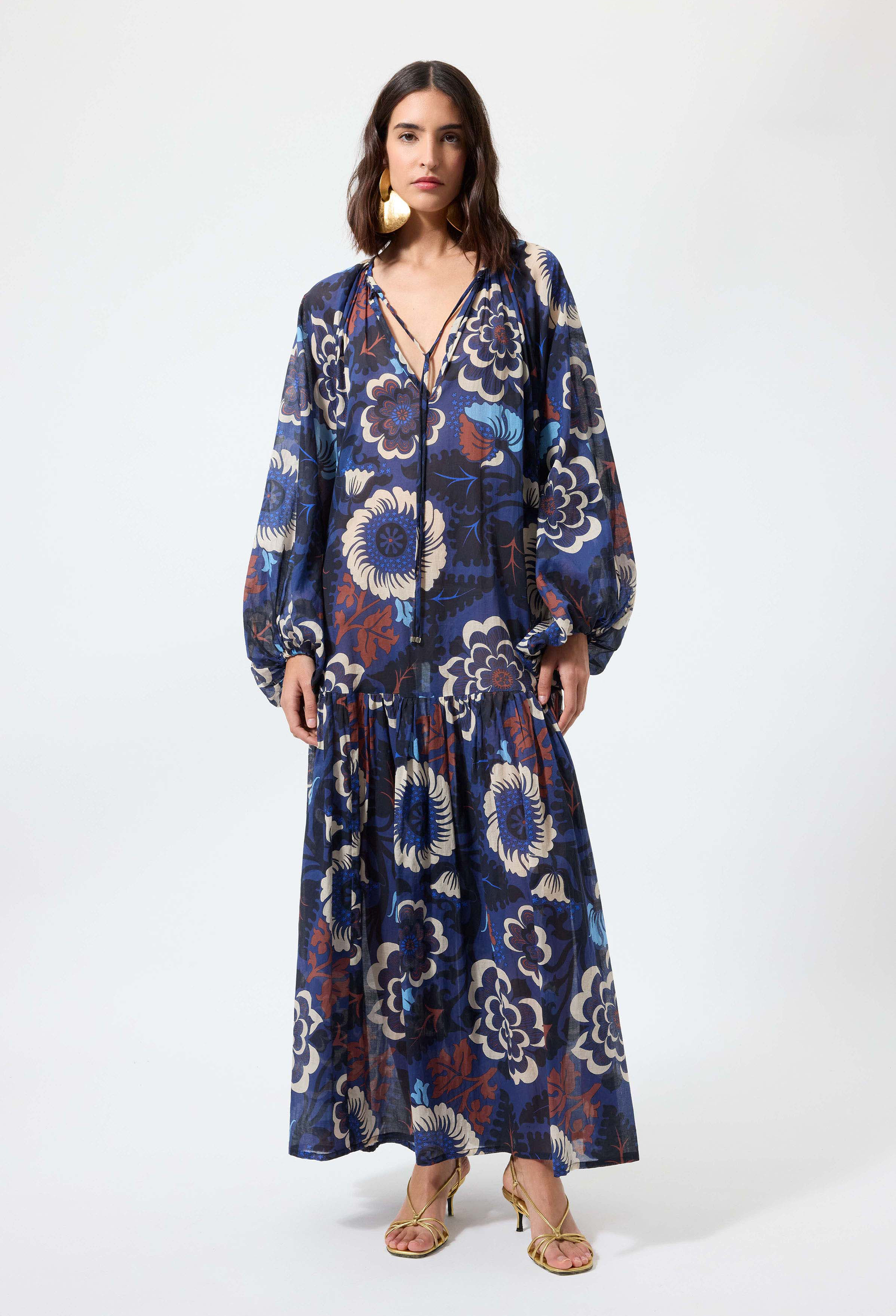 Woman wearing a blue floral patterned dress on a white background