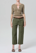 Person wearing a green top and pants with a belt on a white background
