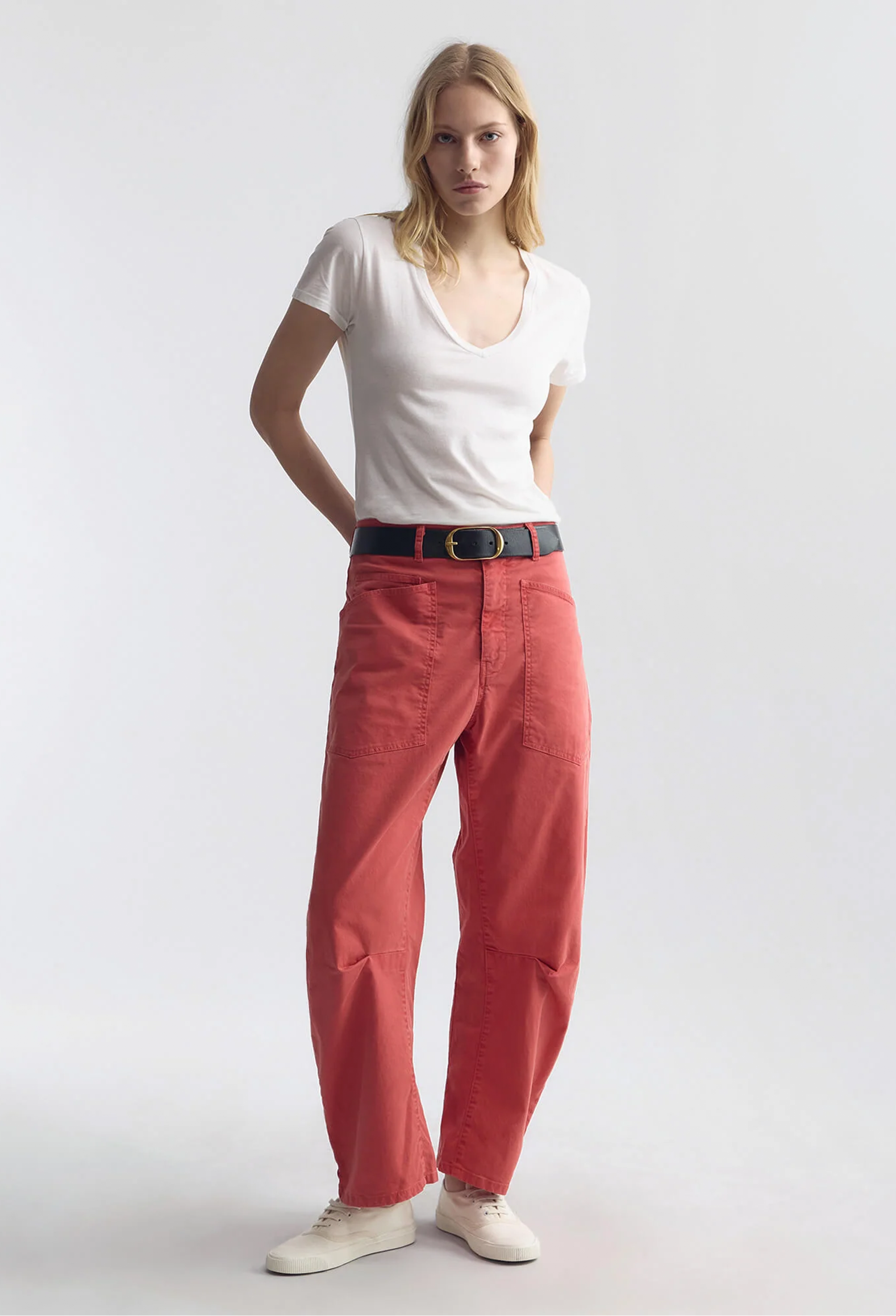Woman wearing a white t-shirt and red pants on a white background