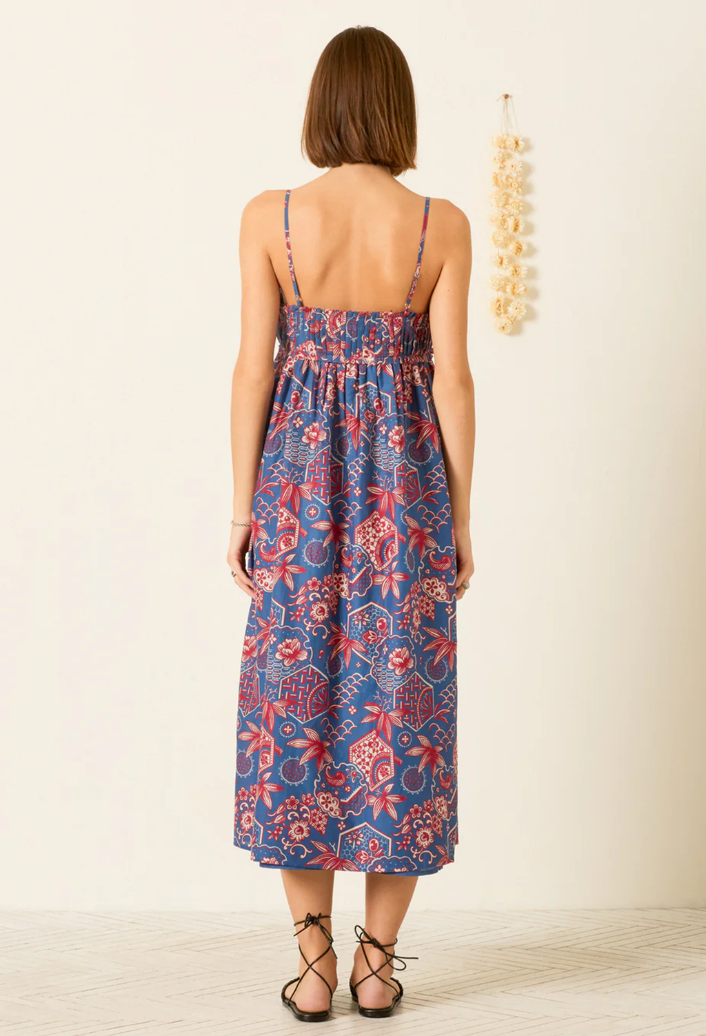 Woman wearing a floral dress with a plain background