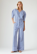 Woman wearing a blue and white striped jumpsuit on a white background