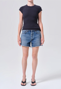 Person wearing a black t-shirt and denim shorts on a white background