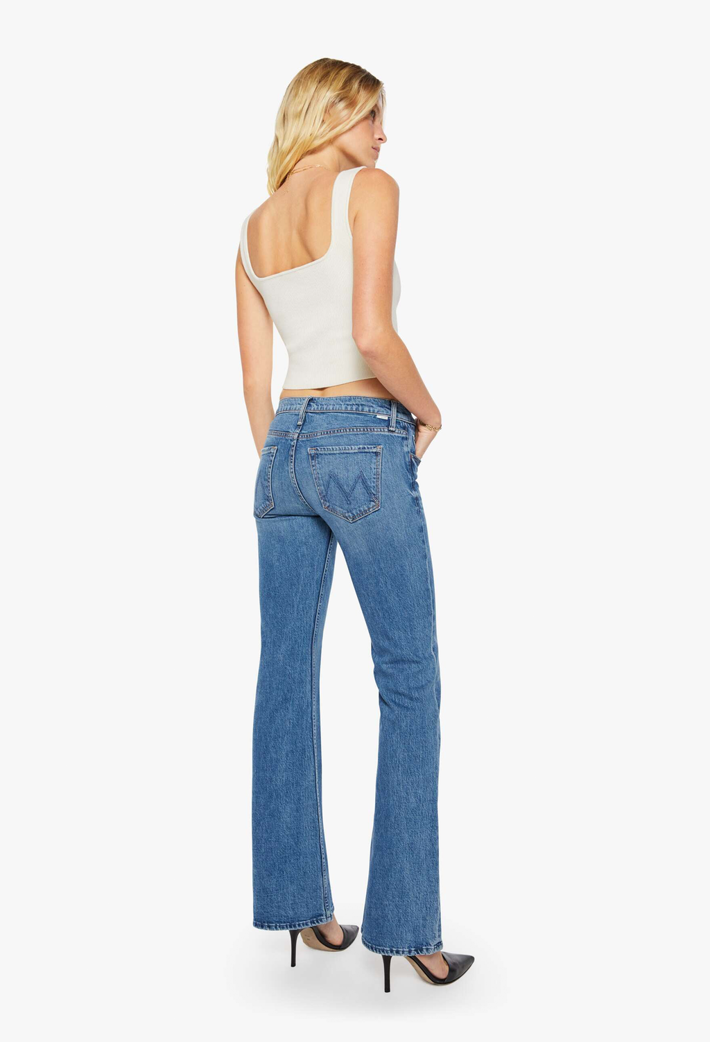 Woman wearing blue jeans and a white top on a white background