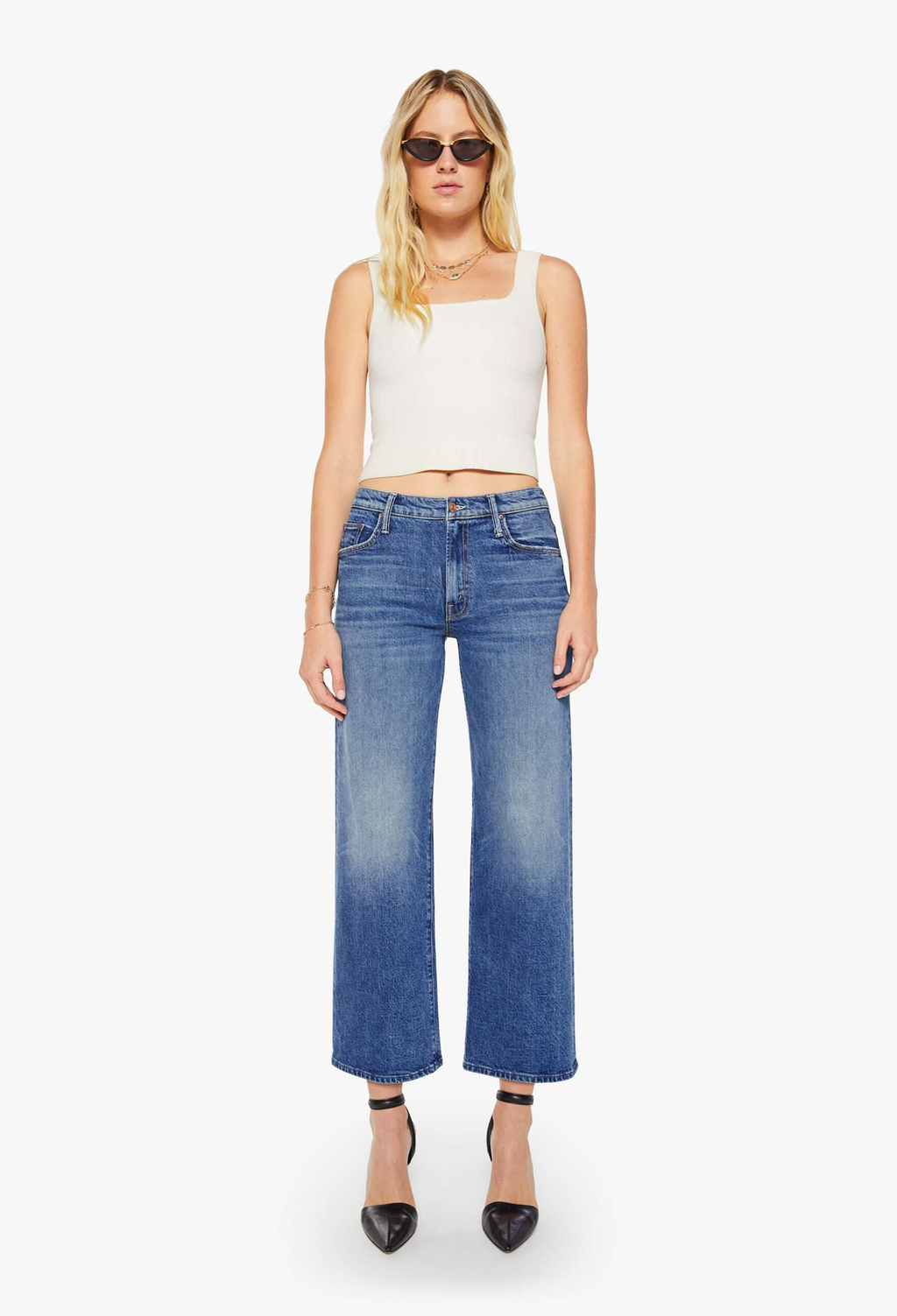 Woman wearing a white top and blue jeans on a white background