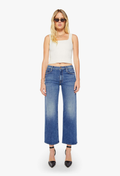 Woman wearing a white top and blue jeans on a white background