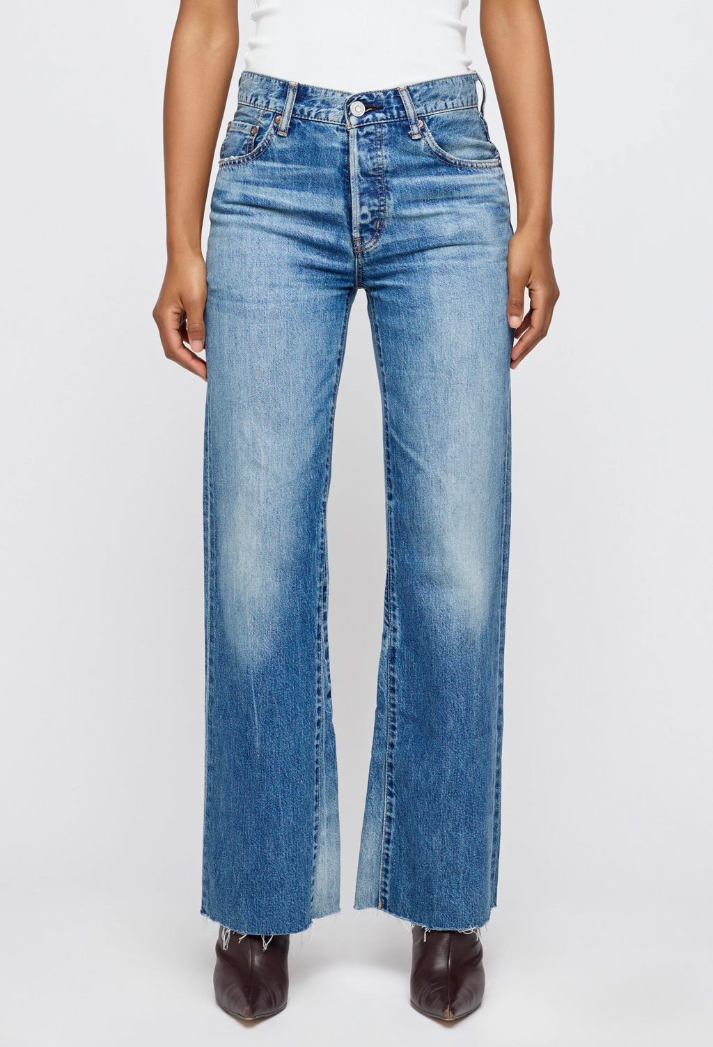 Person wearing blue jeans on a white background