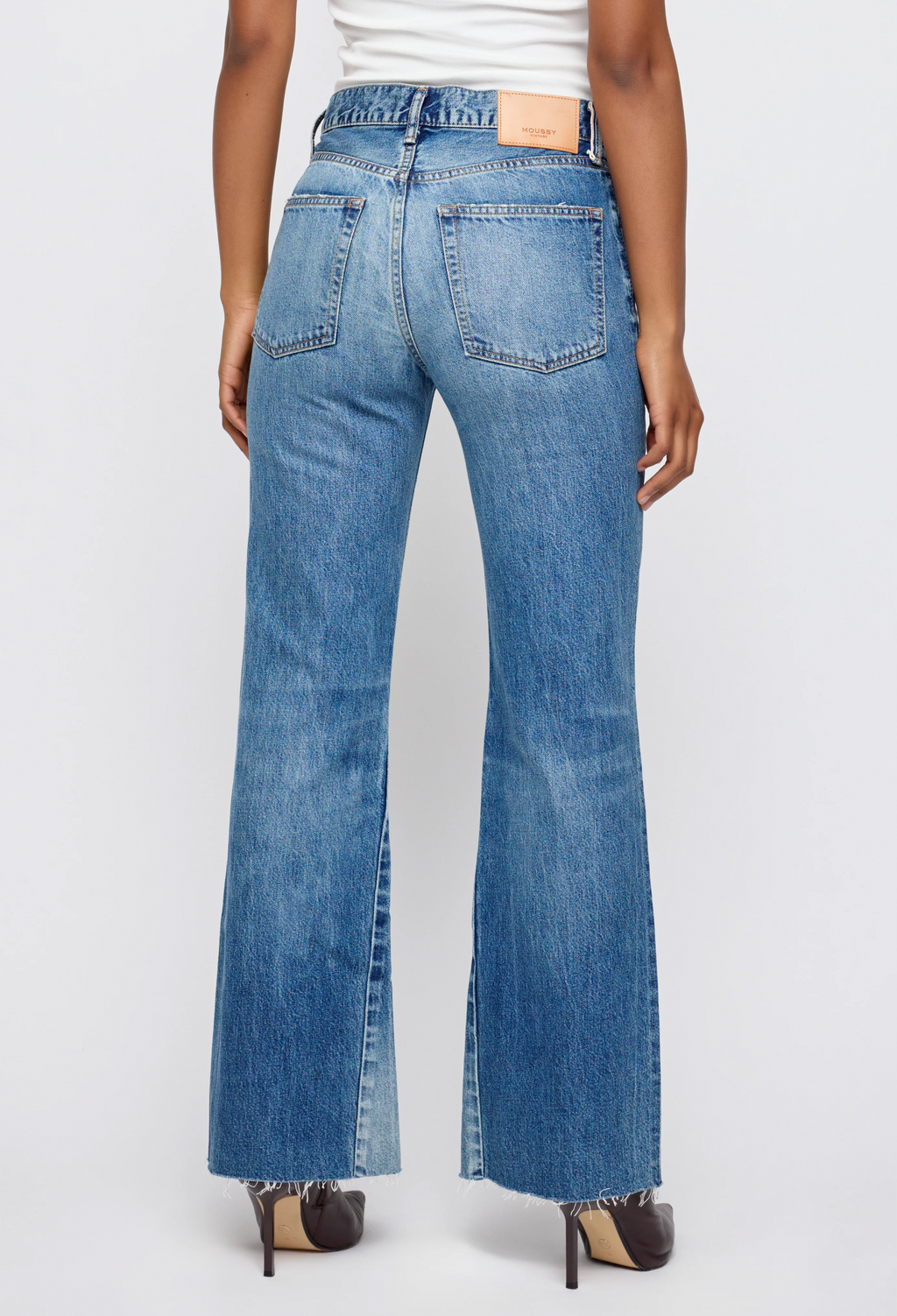Blue jeans worn by a person on a white background