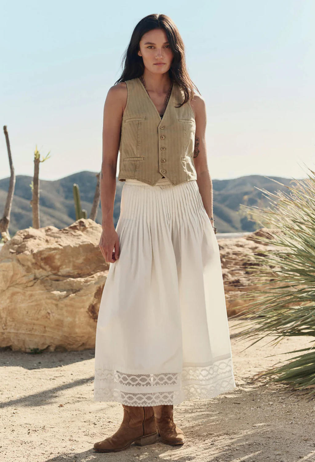 woman wearing a white skirt and beige vest outdoors