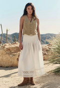 woman wearing a white skirt and beige vest outdoors