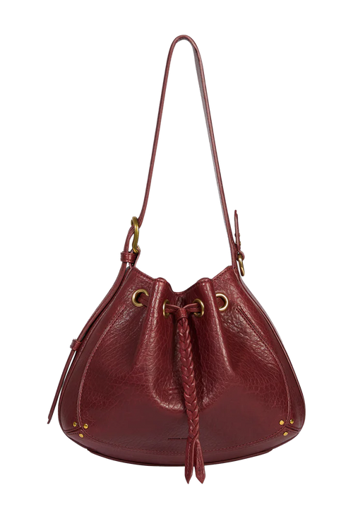 A burgundy pebbled leather bucket bag with a braided leather tassel, gold-tone hardware, and a single shoulder strap, shown against a plain white background.