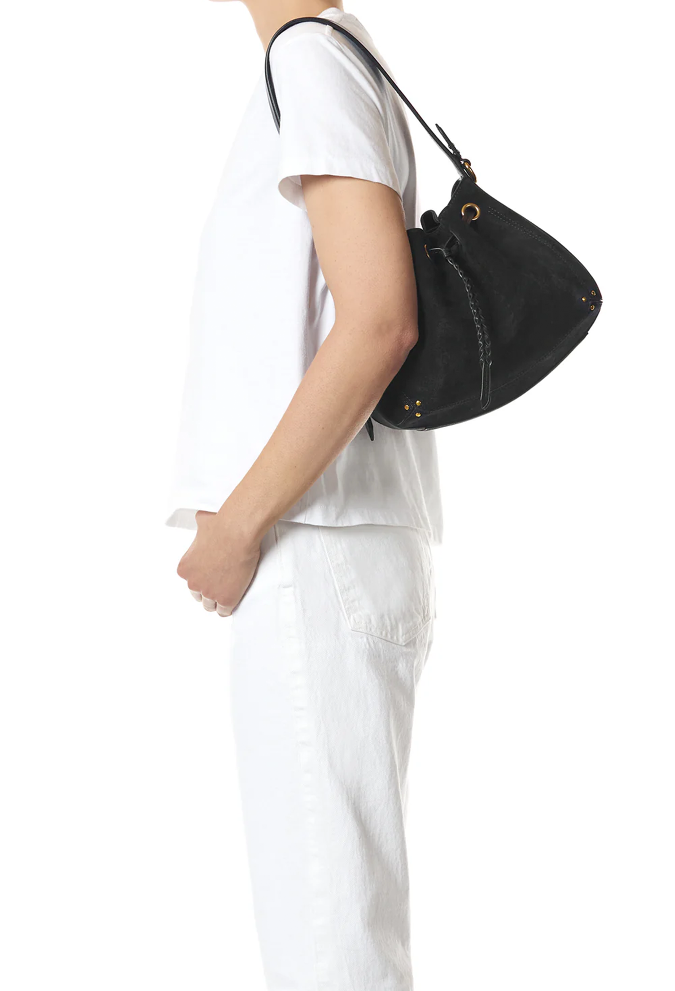 A person in a white t-shirt and white pants shown from the side, wearing a black shoulder bag with a long strap and gold-tone hardware against a plain white background.