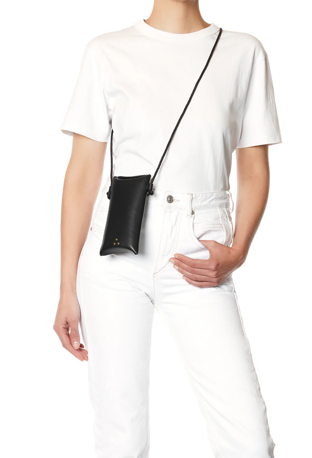 A model wearing a white t-shirt and white jeans, carrying a small black leather crossbody pouch bag with a thin black strap.