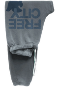 Gray sweatpants with a large dark blue 'FREE CITY' text and dove graphic printed on the upper leg, featuring an elastic waistband and drawstring.