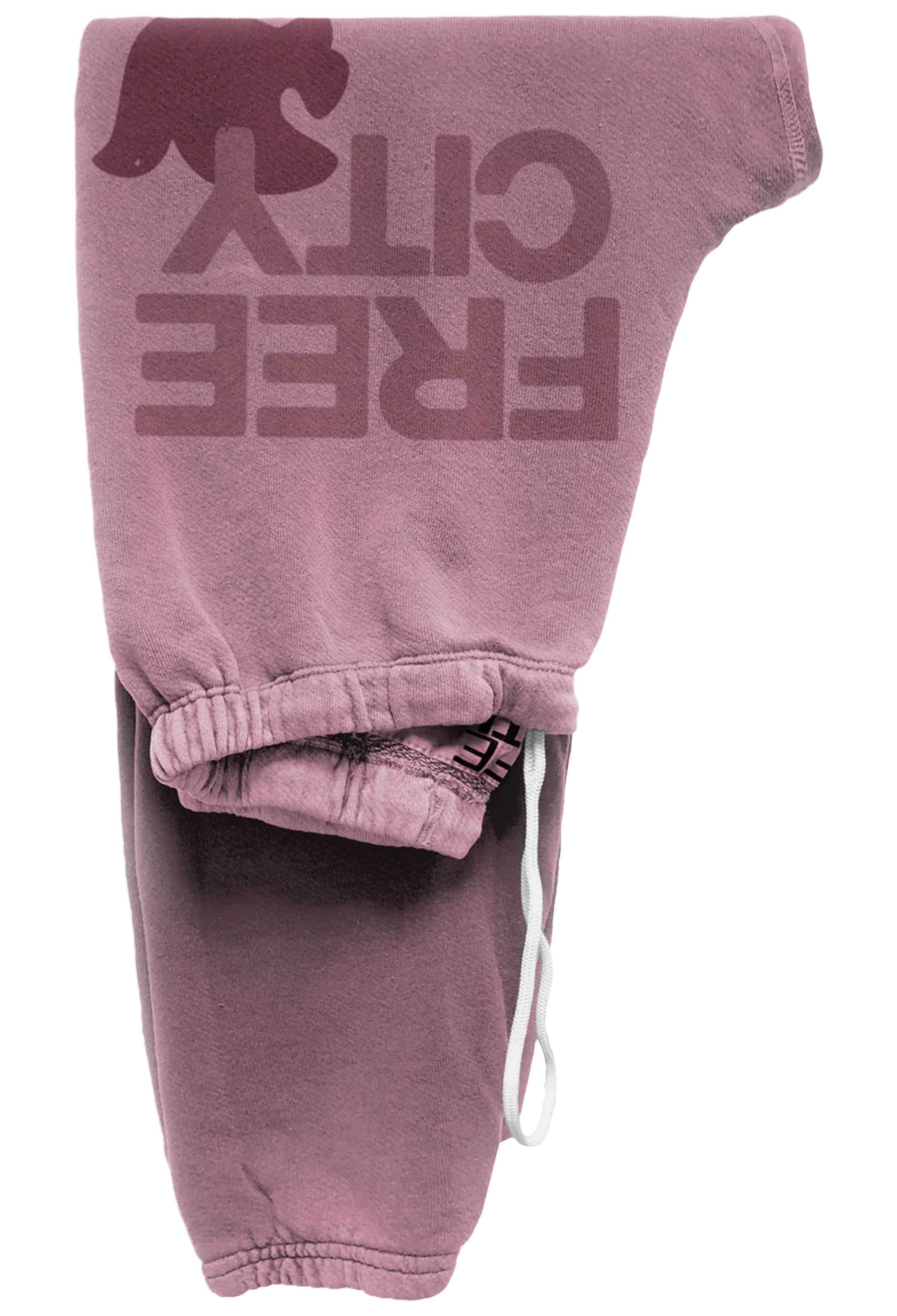 A pair of faded dusty rose sweatpants featuring a large tonal 'FREE CITY' graphic with a bear silhouette on the leg, shown folded on a white background.