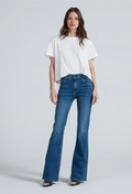 A model wearing a white short-sleeve t-shirt and blue high-waisted flare jeans, standing against a light gray studio background.