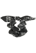 A black fabric scrunchie with a white paisley bandana print, shown against a plain white background.