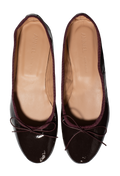 A pair of dark burgundy patent leather ballet flats with a satin trim and a small bow on the toe, shown from a top-down view on a white background. The tan insoles display the brand name 'ANNIEL'.