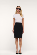 A woman modeling a white short-sleeve crewneck top and a black knee-length pencil skirt, styled with black sunglasses and black heels against a plain white studio background.