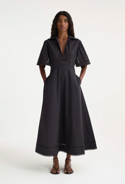 A woman wearing a collared black short sleeve midi dress. Transparent background.