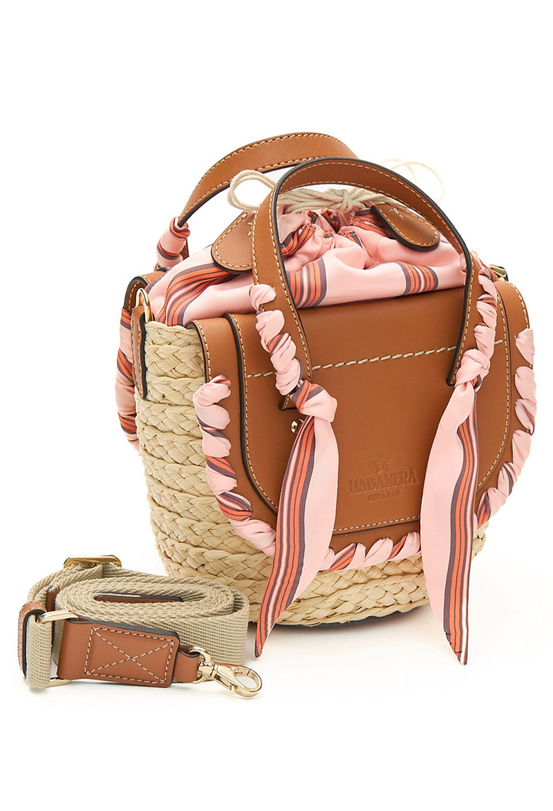 A mini basket bag with beige leather flaps, pink ribbon detailing, and two small leather handles and a crossbody strap. Transparent background.