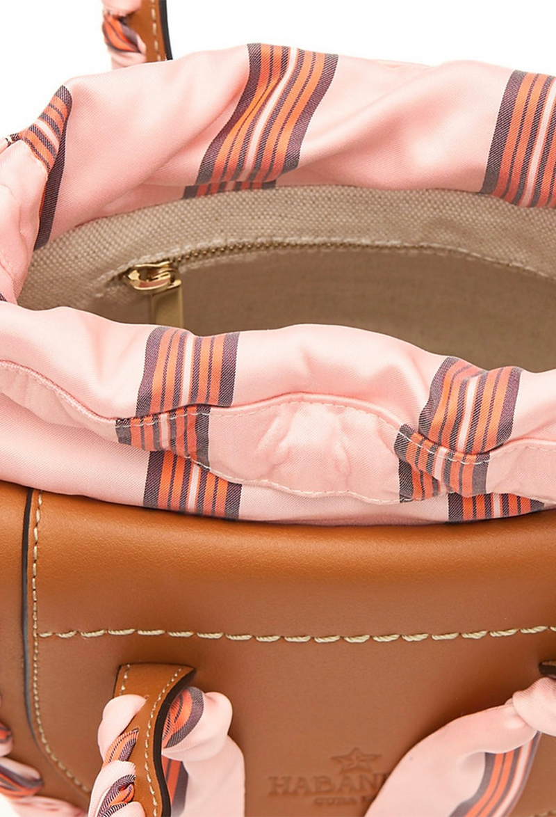 A close up of the inside zip pocket of a mini basket bag. White background.