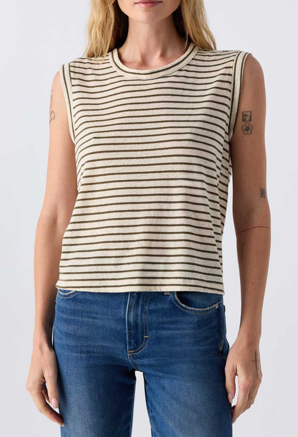 Close up of a woman wearing jeans and an off white sleeveless tee with brown stripes. Taken on a white background.