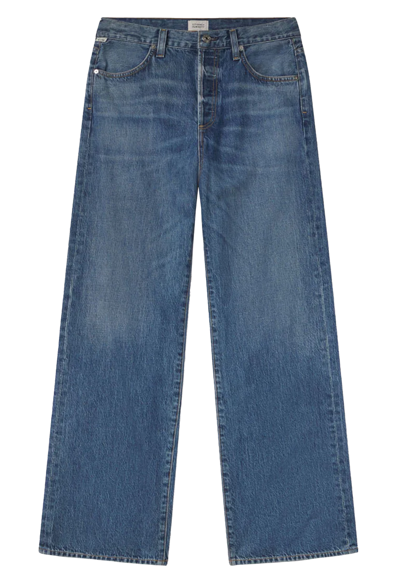 Wide leg dark wash blue jeans set against a checkered background. 