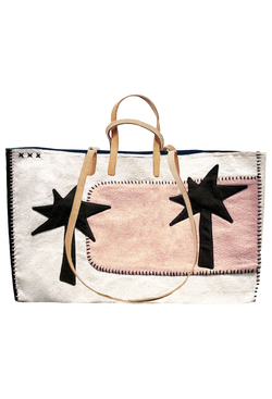 Large white tote with stitched pink patch on the left with two black palm trees on each side of the bag. A pair of long tan handles for shoulder, and short tan handles for carrying. 