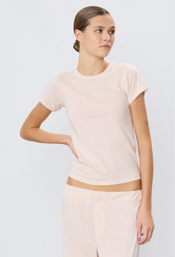 a woman wearing a light pink short sleeve fitted t-shirt. white background.