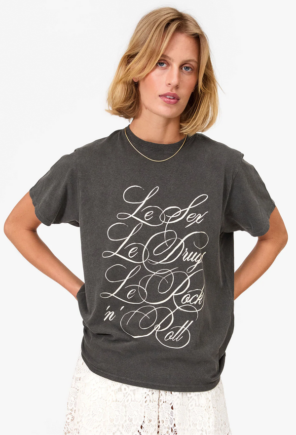 a woman wearing a faded black t-shirt with le sex, le drugs, le rock 'n' roll printed in fancy white font. white background