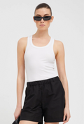 a woman wearing a scoop neck ribbed white tank top tucked into black shorts. white background