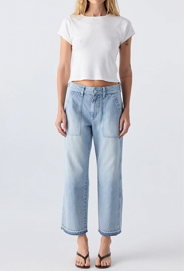 woman wearing a white t-shirt and pinstriped light wash jeans with two deep patch pockets. white background