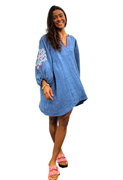 A woman wearing a blue v-neck mini dress with white/red floral embroidery on balloon sleeves. Transparent background.