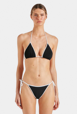 A woman wearing a black triangle string bikini with white borders. white background.