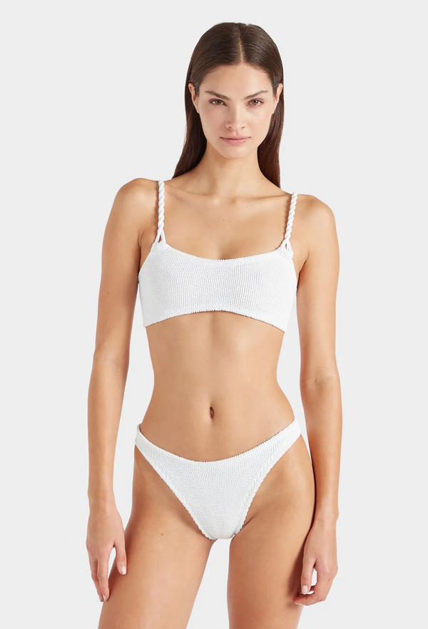 a woman wearing a white bikini with crinkle fabric. white background.