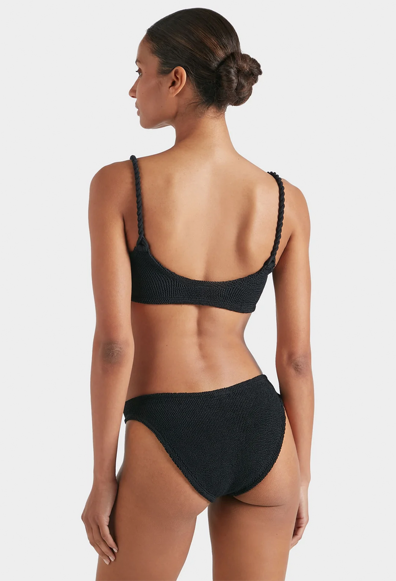 the back of a woman wearing a black bikini with crinkle fabric. white background.