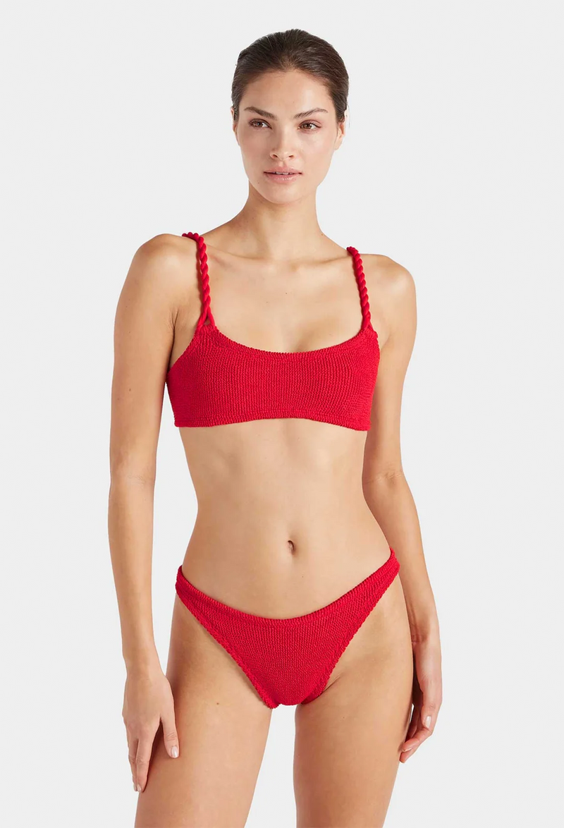 a woman wearing a red bikini with crinkle fabric. white background.